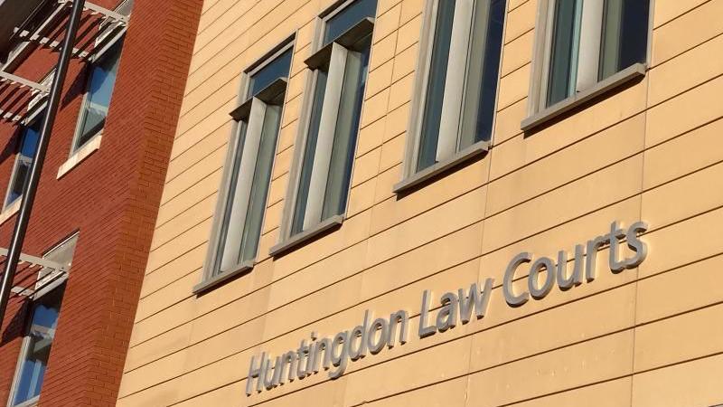 The words "Huntingdon Law Courts" written in silver on the side of a yellow building