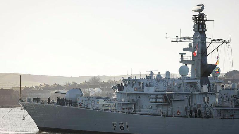 HMS Sutherland on water. It is a large grey ship and has the "F81" in black on the side. 