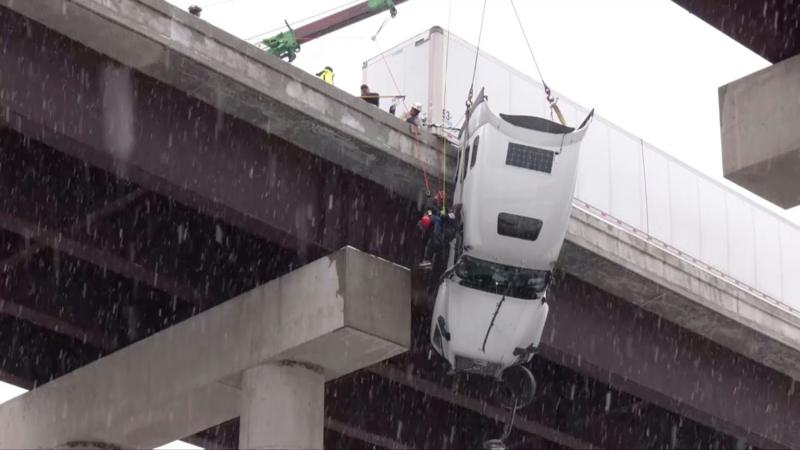 Watch: Driver hoisted to safety from truck dangling over West Virginia bridge