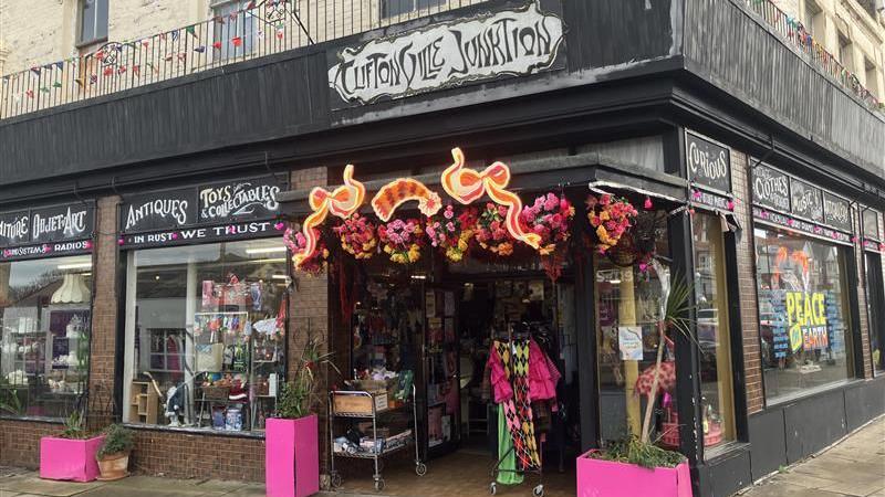 Cliftonville Junktion vintage shop on Northdown Road with pink planters outside the entrance and a sign in the window that reads 'Peace On Earth'