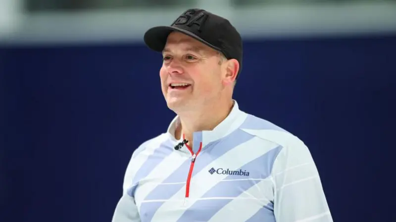 Richard Ruohonen smiles and is wearing a black baseball caps with a two-toned blue striped t-shirt