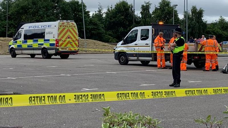 Police vans, a police cordon and clean-up personnel at the Holiday Inn Express at Manvers