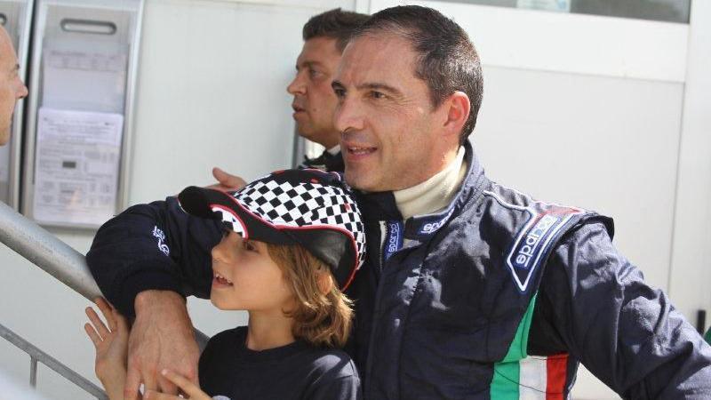 Kimi Antonelli, aged about nine, pictured with his dad Marco, who is wearing a racing overall