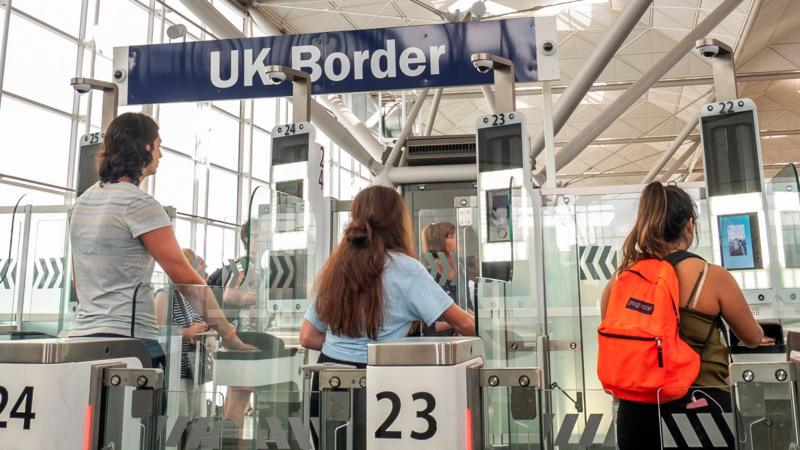 What is the UK's new travel system and how are dual nationals affected?