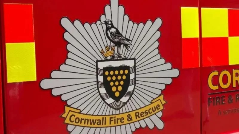 A Cornwall Fire and Rescue crest on the red door of a fire engine.