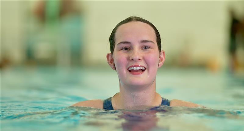 Christina smiling as her head and shoulders are above the surface level of the water