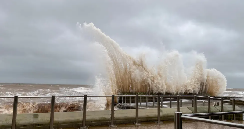 Waves crash into the seafront in Devon on Saturday. Lots of spray and foam around the railings 