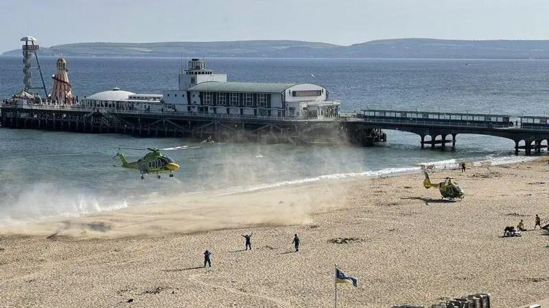 A helicopter landing on the beach near Bournemouth Pier