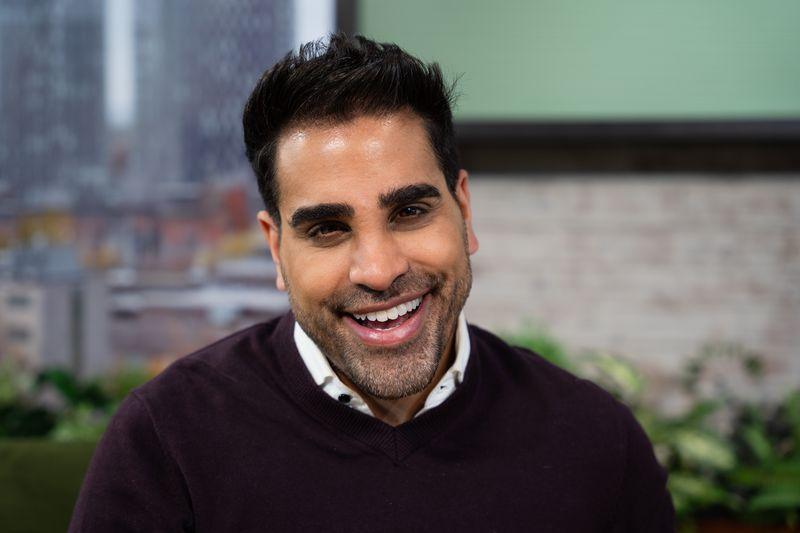 Dr Ranj smiling in the Morning Live studio, wearing a burgundy jumper with a white shirt underneath.