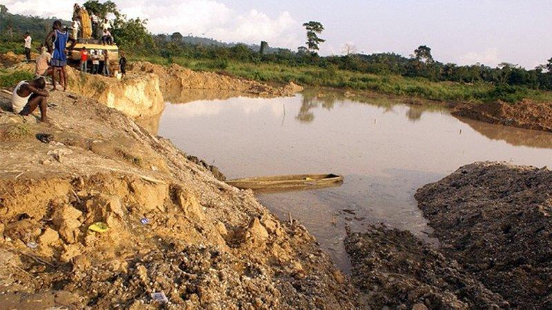 A boy sits beside the pit where miners died when the roof of an illegal gold mine collapsed at Dunkwa on-Offin in central Ghana (27 June 2010)