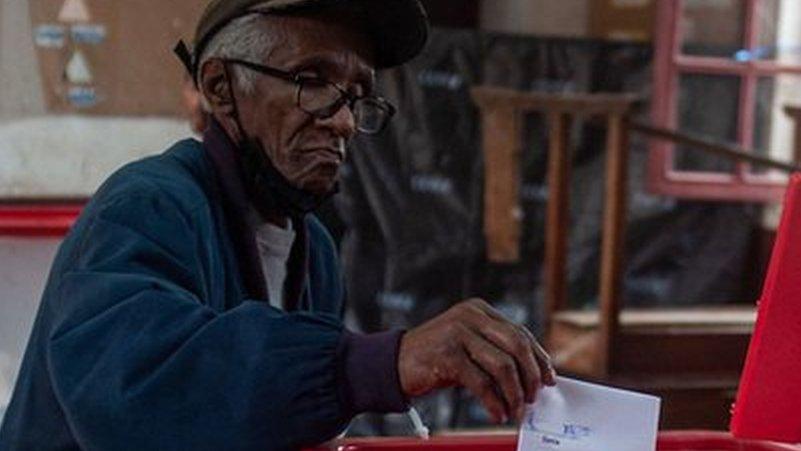 A man casts his ballot in the box