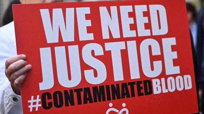 Placard calling for justice for those impacted by contaminated blood