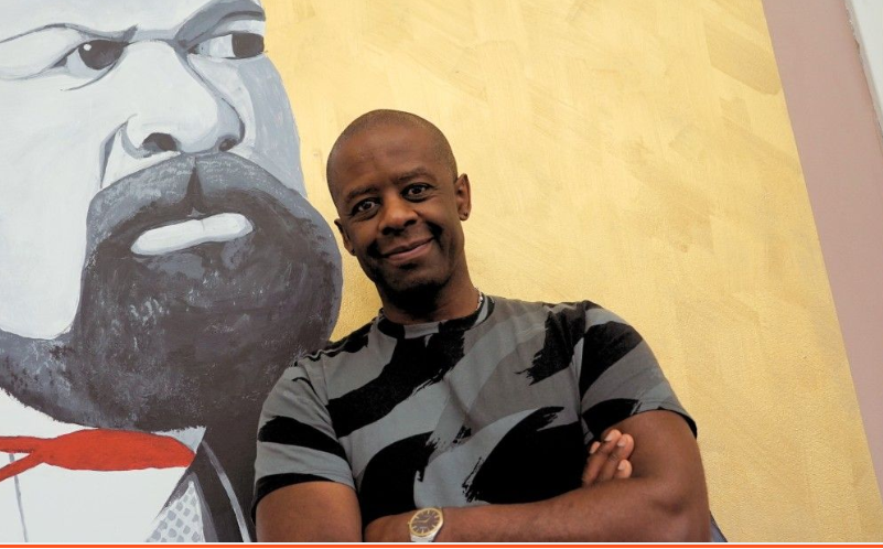 Actor Adrian Lester standing next to mural at SCRUM theatre