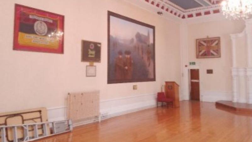 One of the rooms at the hall that has paintings, with a wooden floor and while walls