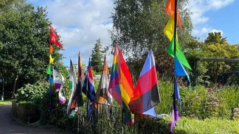 A series of colourful flags on a fence at Swindon Pride