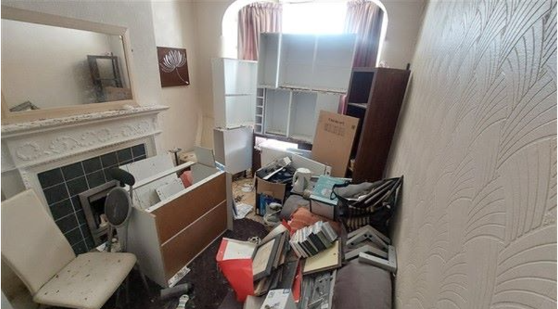 Another room in the house, but this one is covered with empty shelves, books, and other disused furniture