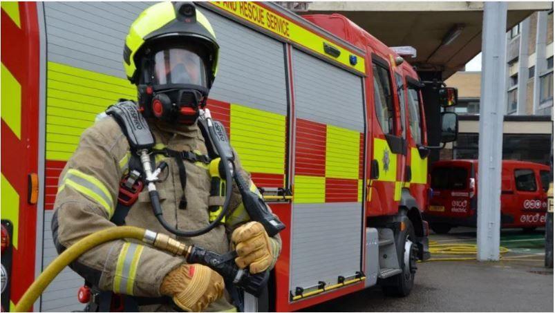 A firefighter standing in front of a fire engine