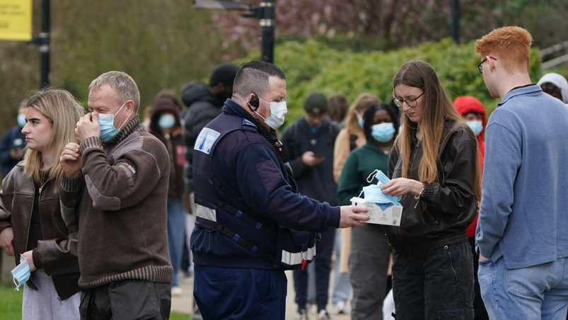 Maskat e fytyrës u jepen studentëve ndërsa ata presin në radhë për antibiotikë jashtë një ndërtese në Universitetin e Kentit në Canterbury.