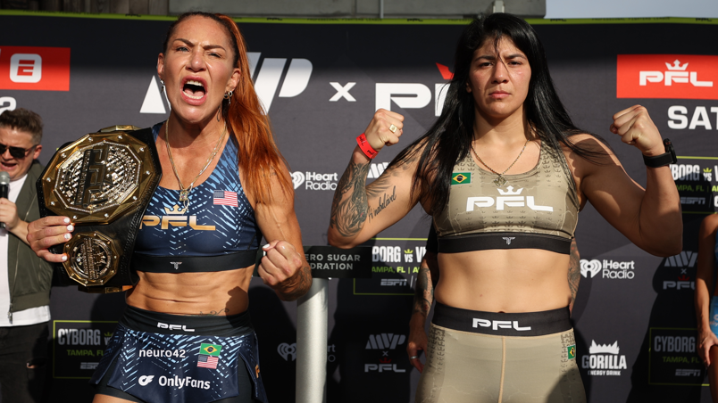 Cris Cyborg with her title over her shoulder as she weighs in beside Ketlen Vieira