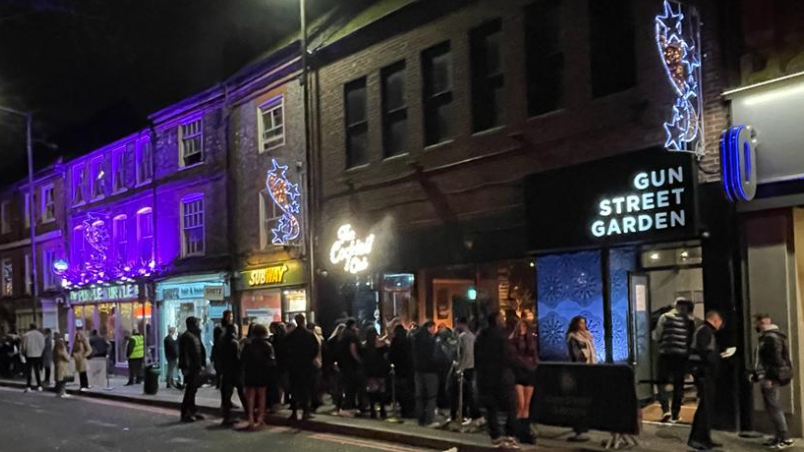 Queues and smokers outside the Cocktail Club and Gun Street Garden in Gun Street on a Friday night in Reading town centre