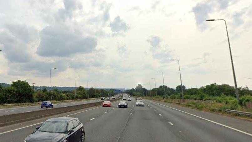 Vehicles travelling along the M5, near grass verge. 