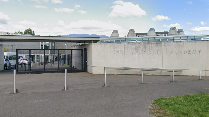 A general view picture of the John Madejski Academy in Reading, which has a stone wall with "John Madesjski Academy" carved into it.