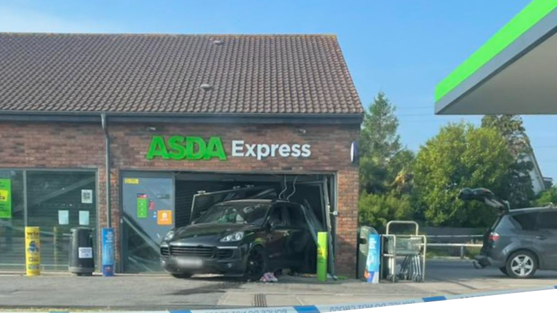 A Porsche Cayenne that is reversed into a shop window at an Asda Express petrol station. Police tape is across the forecourt.