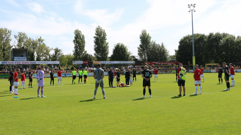 Southport and FC United of Manchester players hold a minute's silence before a friendly match at Southport's Big Help Stadium on 3 August