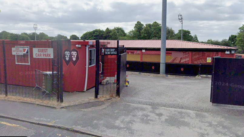 The front entrance of Salford City's stadium with a red cabin on the left hand side