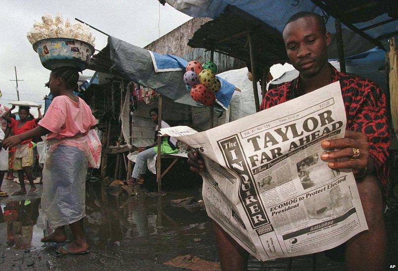 A Liberian man in the Monrovia market reads the city newspaper with preliminary election results showing warlord Charles Taylor leading 22 July 1997