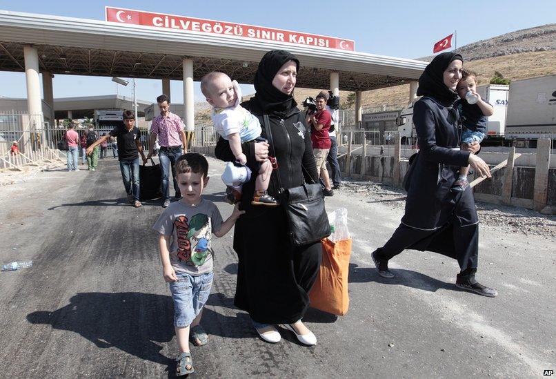 Syrian refugees pass through the Turkish Cilvegozu gate border, Saturday, Aug. 31, 2013.