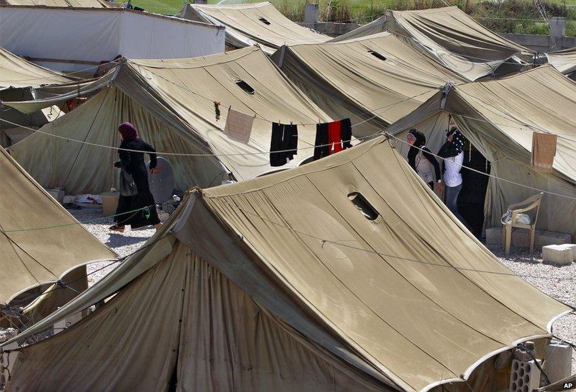 Syrian refugees women stand outside their tents, at a temporary refugee camp in the eastern Lebanese town of Marj near the border with Syria, Lebanon