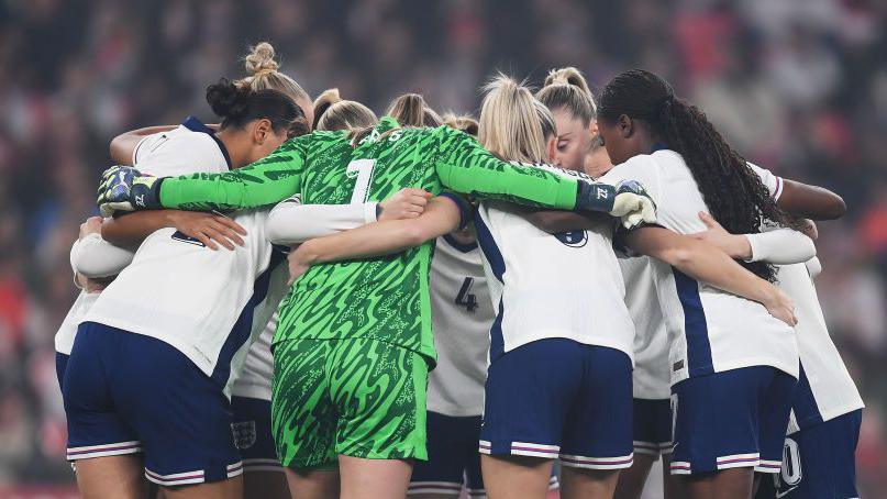 England players form a huddle on the pitch before an international friendly with the USA