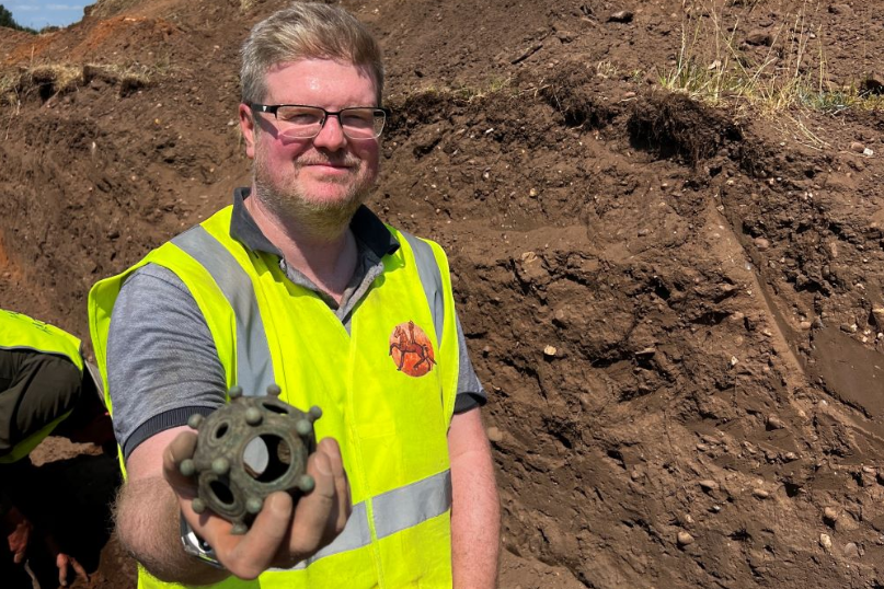 Man from the Norton Disney History and Archaeology Group holding the rare Gallo-Roman dodecahedron at the site it was found in Lincolnshire.