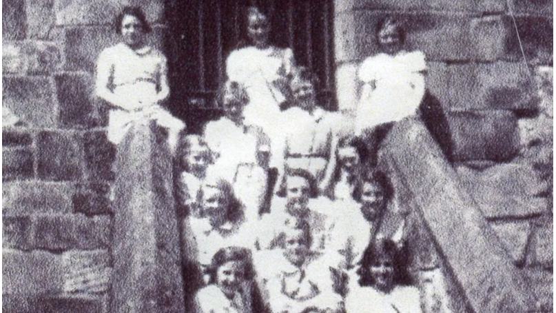 A black and white picture of girls sitting on steps