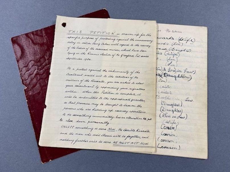 A notebook page with a handwritten petition calling for the recovery of the dead with many names written on it.