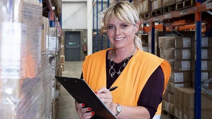 Sarah Stoute wearing a high-visibility gilet and holding a clipboard and pen