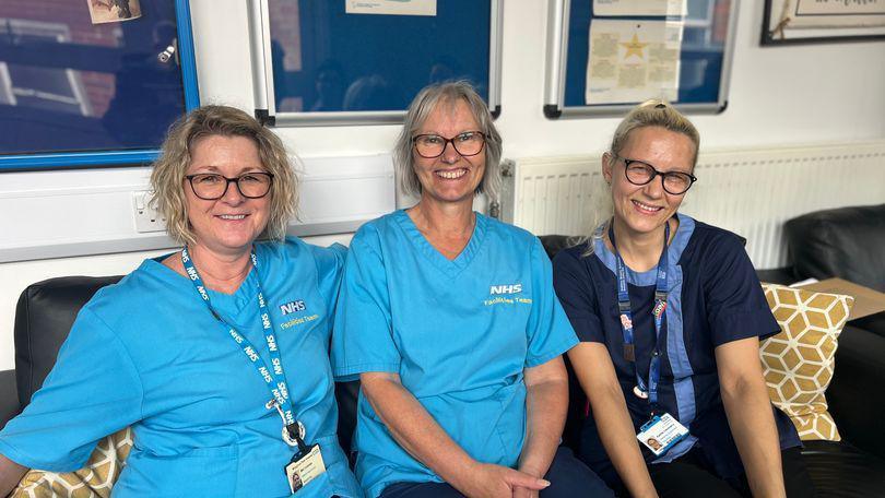 Three NHS workers sat on a sofa