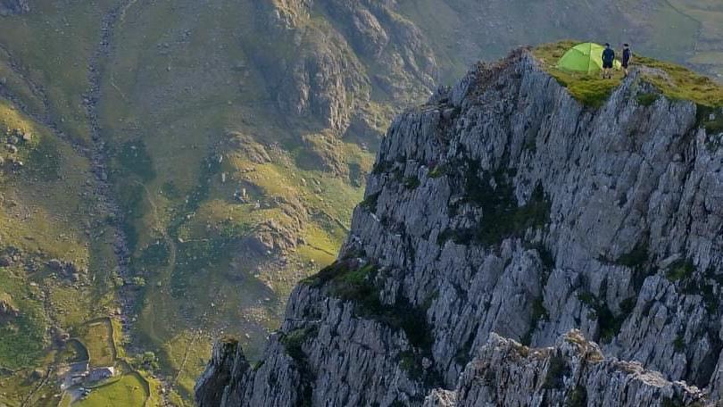 View of the clifftop and drop with tent pitched on top