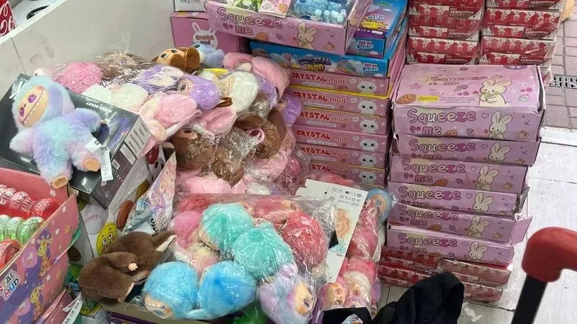 Colourful counterfeit Labubus are seen in a pile of plastic bags
