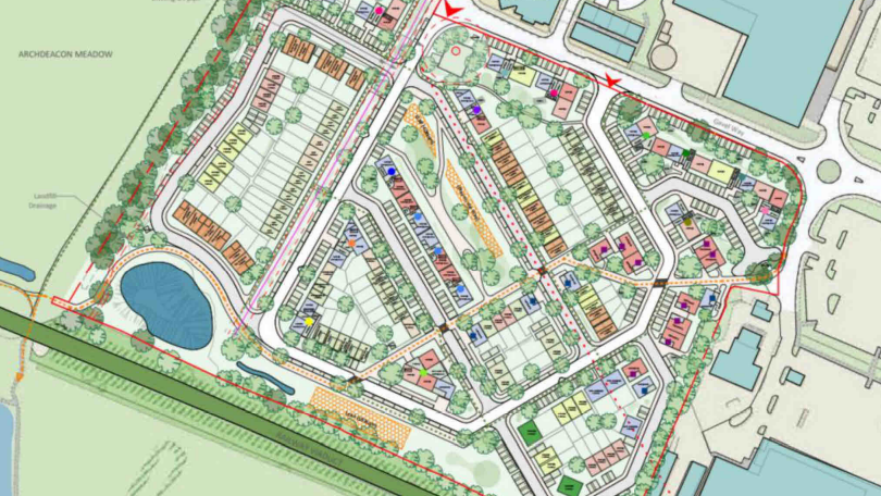 A colour map of a the proposed development showing a railway embankment, a roundabout, roads, thoroughfares, a pond and rows of different coloured houses with a narrow green space in the middle.