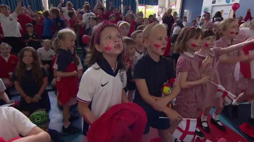 A group of school children watching the England v Mexico game