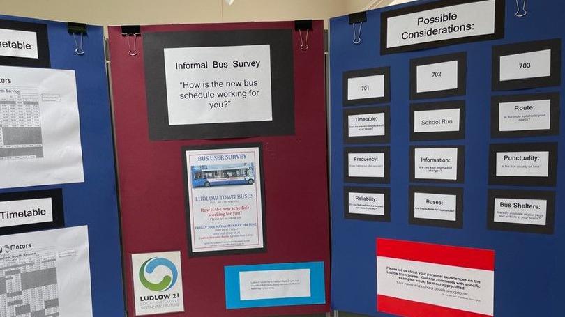 Large felt boards used for the bus survey with sheets of information, including timetables, pinned to them.