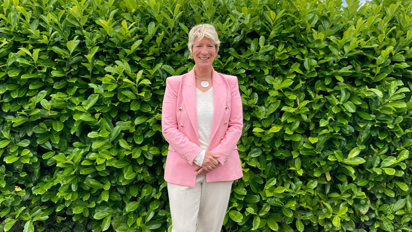 Pippa Heylings standing in front of a hedge