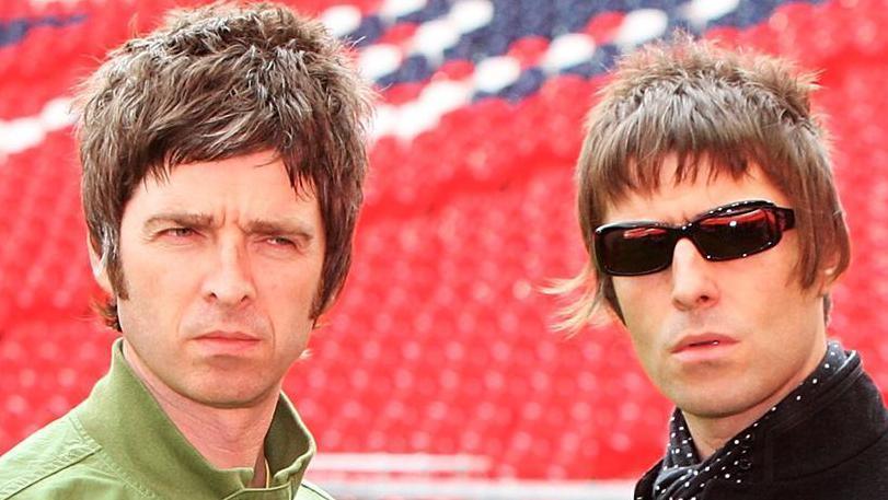 Noel and Liam Gallagher at a football ground
