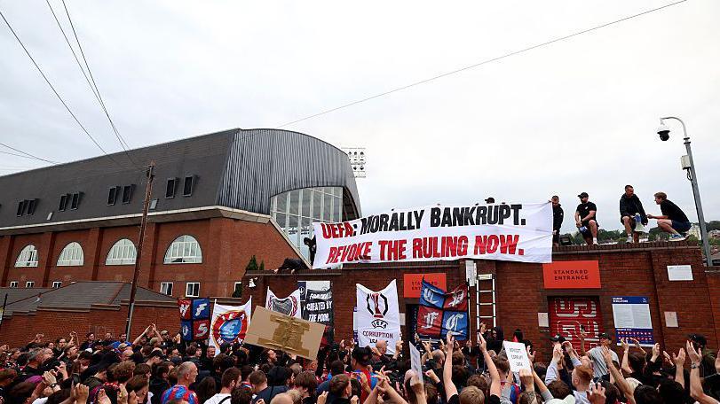 Crystal Palace fans protest at Selhurst Park about their demotion to the Uefa Conference League