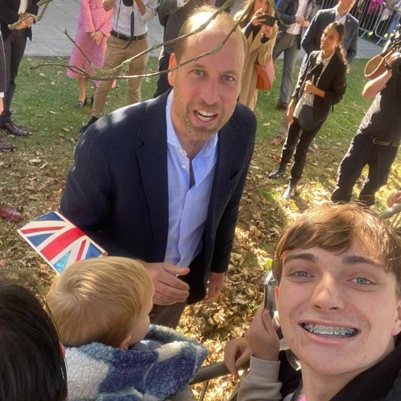 Thomas Croft, who has light brown hair and is smiling, takes a selfie with Prince William outside Birtley Community Pool.