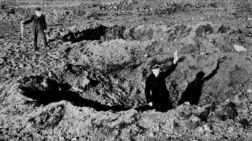 Men holding rabbit and bomb shrapnel