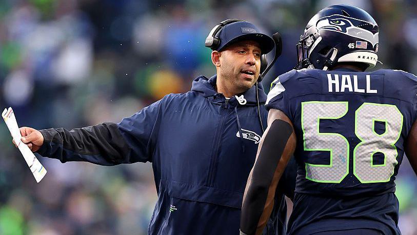 Defensive coordinator Aden Durde talks with Derick Hall of the Seattle Seahawks during the NFC Championship game in January 2026
