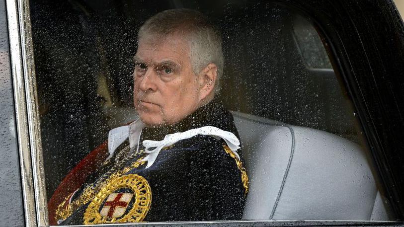Prince Andrew in ceremonial robes in the back of a car